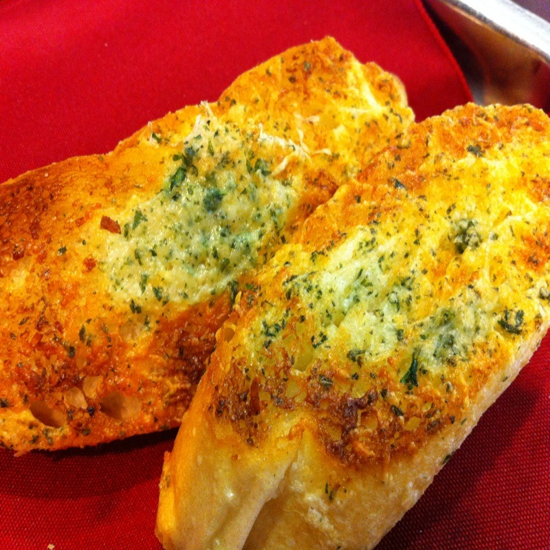 Who invented garlic bread and when